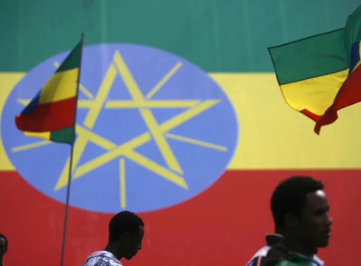 People walk in front of Ethiopian flags
