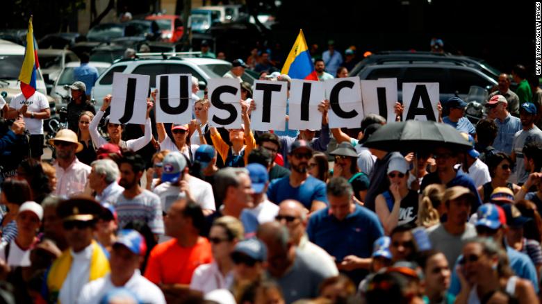 Demonstrators hold banner that reads "Justice" during a rally of the opposition with the self-proclaimed interim president Guaido in Caracas, January 25, 2018. Marco Bello