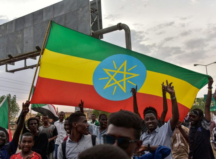 Men wave a large Ethiopian flag as people celebrate outside the Friendship Hall in the capital Khartoum where generals and protest leaders signed a historic transitional constitution meant to pave the way for civilian rule in Sudan, on August 17, 2019. - Sudan was poised to celebrate a historic deal between generals and protest leaders for a transition to civilian rule, which many hope will bring increased freedom and prosperity. (Photo by Ahmed Mustafa / AFP)        (Photo credit should read AHMED MUSTAFA/AFP via Getty Images)